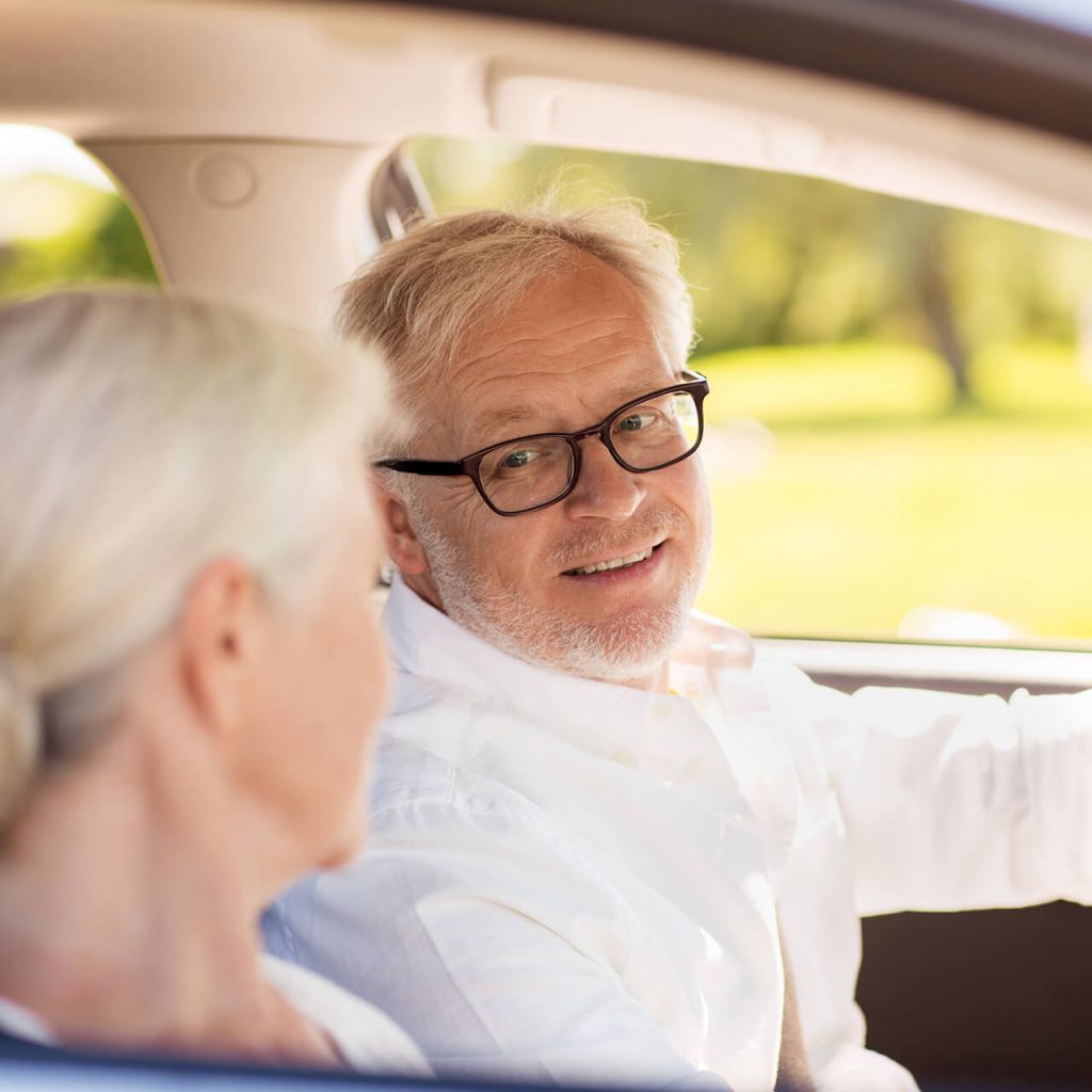 Senioren sitzen im Auto und blicken sich an